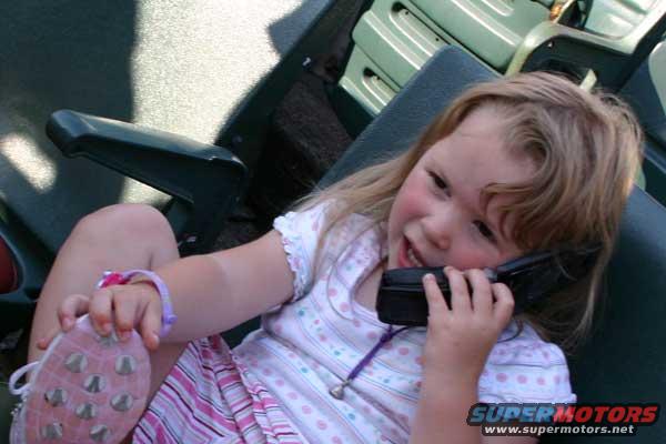 Child with pink shoe and phone