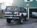 1994 Ford Bronco - This lifted Ford Bronco is parked outside a garage with another truck visible inside.