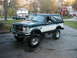 1994 Ford Bronco - This lifted Ford Bronco features a two-tone paint scheme and aggressive off-road tires.