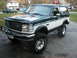 1994 Ford Bronco - This lifted Ford Bronco features a two-tone paint scheme and aggressive off-road tires.