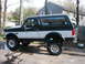 1994 Ford Bronco - Side profile of a lifted 1994 Ford Bronco with aftermarket wheels and tires.