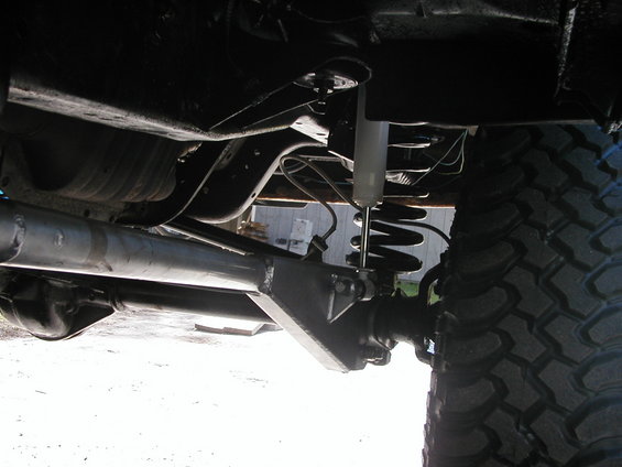 Undercarriage view showing suspension, shock absorber, coil spring, and large tire tread
