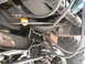 1994 Ford Bronco - Close-up view of the engine bay and suspension system of a vehicle, with various hoses and mechanical parts visible.
