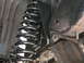 1994 Ford Bronco - Close-up view of a vehicle's suspension system, showing a coil spring and frame components.