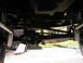 1994 Ford Bronco - A low-angle shot captures the underside of a vehicle, focusing on the rear axle and suspension system.