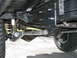 1994 Ford Bronco - Close-up of aftermarket suspension parts on a vehicle's undercarriage.