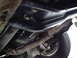 1987 Ford Bronco - A close-up view of the undercarriage of a vehicle, showing the exhaust system and a tire.