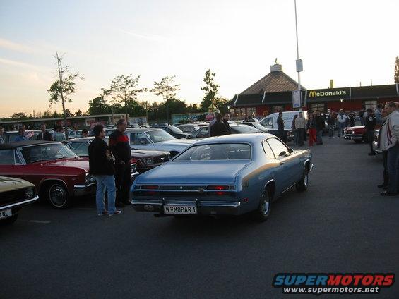 Blue coupe with a "W MOPAR 1" license plate, parked at a car meet
