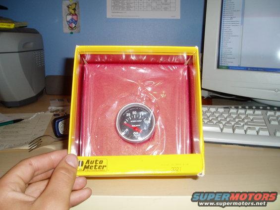 Auto Meter oil pressure gauge in yellow box with red insert