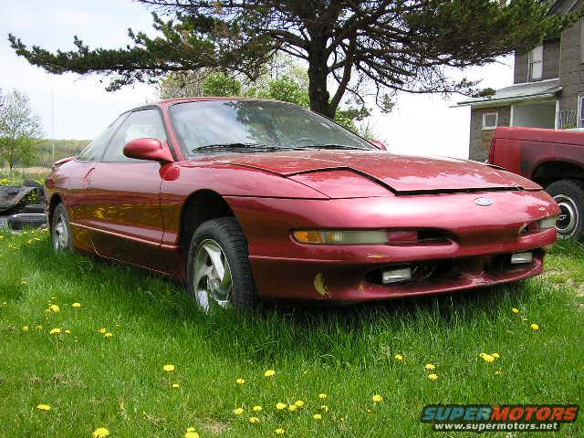 Red 1994 Ford Probe front-left view in grassy yard