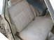 1985 Ford Crown Victoria LTD - Interior view of car seats with beige fabric upholstery and a dark blue trim piece visible.