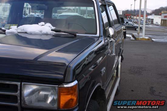 Black 1989 Ford Bronco 3q-front view with snow on hood