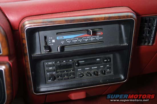 1989 Ford Bronco interior showing red dashboard, climate controls, and Ford radio