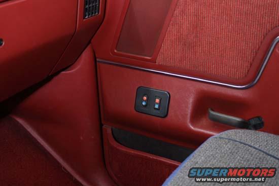 Red interior door panel with power window switches and fabric insert. 1989 Ford Bronco