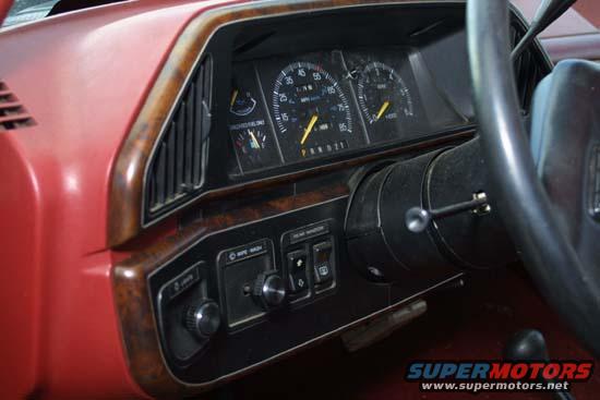 1989 Ford Bronco interior dashboard with gauges and wood trim. PRND21 gear selector visible