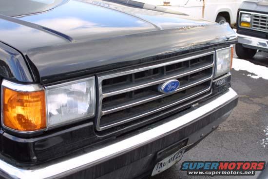 Black Ford Bronco front grille with blue Ford oval emblem. License plate visible