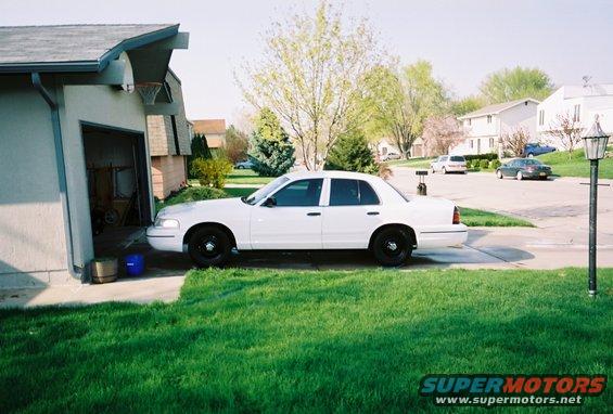 White 2000 Ford Crown Victoria parked in driveway, side view