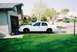 2000 Ford Crown Victoria - A white 2000 Ford Crown Victoria is parked in a suburban driveway next to a garage.