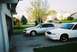 2000 Ford Crown Victoria - Two Ford Crown Victoria sedans, one silver and one white, are parked in a suburban driveway.