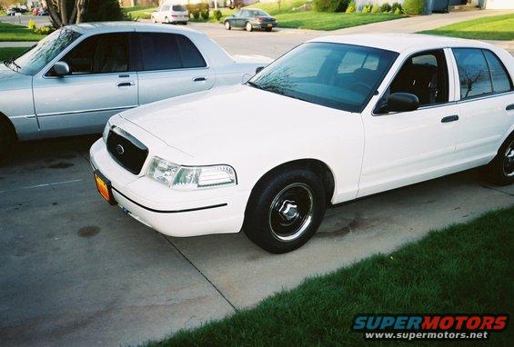 White 2000 Ford Crown Victoria parked next to a silver sedan on a driveway