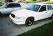 2000 Ford Crown Victoria - Two sedans parked on a driveway, one white Ford Crown Victoria and a silver car.