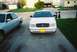 2000 Ford Crown Victoria - A white 2000 Ford Crown Victoria is parked in a driveway, with another car to its left and a garage in the background.