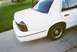 2000 Ford Crown Victoria - A white sedan is parked on a concrete driveway next to a grassy lawn.