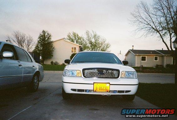 White 2000 Ford Crown Victoria parked in driveway, another car to the left