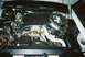 2000 Ford Crown Victoria - The engine bay of a vehicle, showing various mechanical parts and fluid reservoirs.