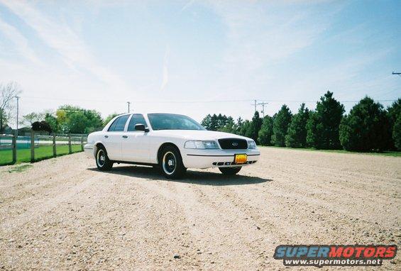 White 2000 Ford Crown Victoria parked on gravel lot