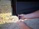 2003 Ford Ranger - A person is removing a car door panel with a screwdriver.