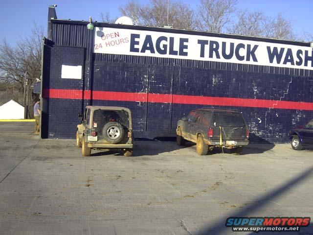 Rear view of Jeep Wrangler and dark SUV at Eagle Truck Wash