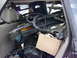 1998 Volkswagen Jetta - The interior of a car is packed with various disassembled parts and a cardboard box, obscuring the view of the vehicle's model year.