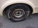 1998 Volkswagen Jetta - A close-up view of a Hoosier tire mounted on a worn wheel, with a portion of the vehicle's body visible.