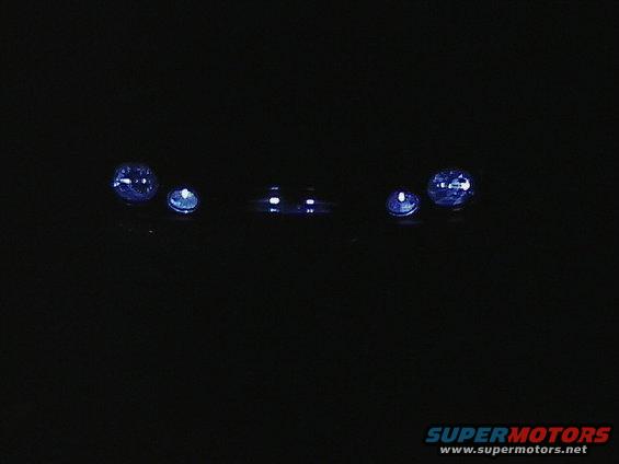 Darkness obscures vehicle; headlights visible