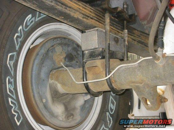 Rear axle assembly with leaf springs and brake drum visible