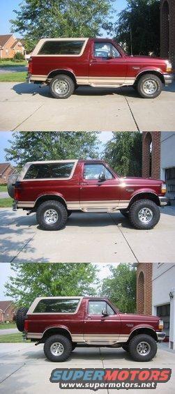 Red Ford Bronco with a tan top, lifted with off-road tires. It's parked on a driveway