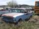 1968 Ford Coupe - A light blue sedan, likely a 1964 model, sits in a junkyard with visible rust on its hood and roof.