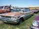 1968 Ford Coupe - A weathered 1963 Ford Galaxie sits in a junkyard next to a tow truck and a yellow school bus.