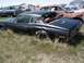 1968 Ford Coupe - Junkyard scene with an abandoned 1967 Mercury Cougar coupe partially hidden by tall grass.