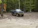 1979 Ford Bronco - Pickup truck navigating a muddy trail in a forest setting.
