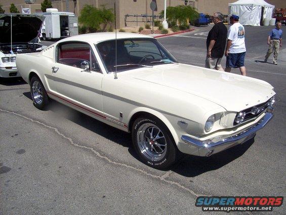 White 1965 Ford Mustang coupe with red interior and side stripe