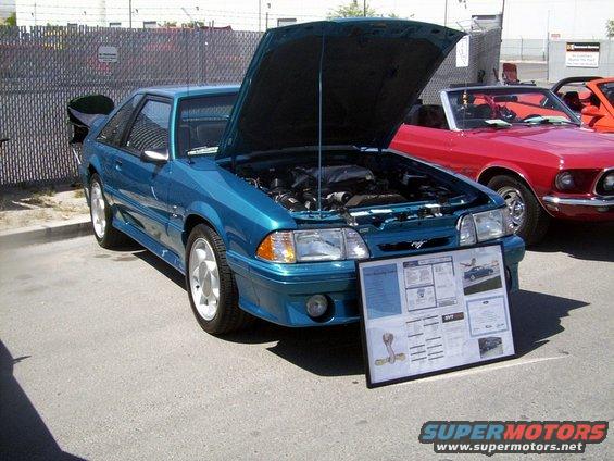 Teal 1993 Ford Mustang SVT Cobra coupe with hood open, display board in front