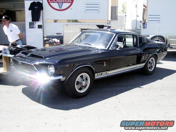 Black 1967 Shelby GT350 with white racing stripes on the side, parked outdoors