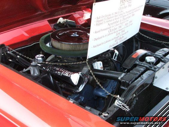 Engine bay with history placard detailing a 1966 vehicle's build and ownership