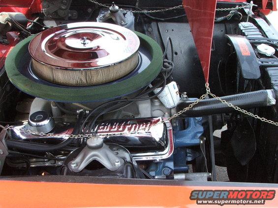 Close-up of a Ford V8 engine with chrome valve covers and a round air cleaner