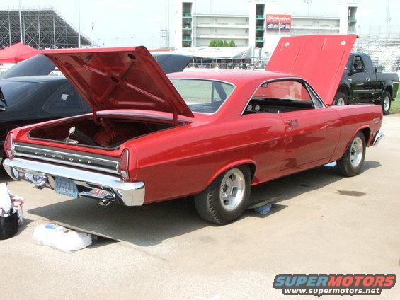 Red 1966 Mercury Cyclone coupe with hoods open, viewed from the rear quarter