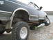 1979 Ford F-150 - A black pickup truck with prominent off-road tires navigates a steep gravel slope.