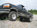1979 Ford F-150 - This black Ford F-150 pickup truck is shown from a low angle, with its front tires on a pile of gravel.