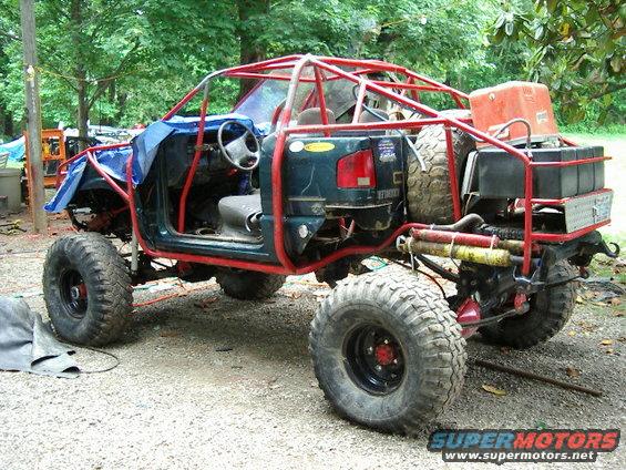 Custom buggy with roll cage, big tires, and spare tire mounted on back. Interior is stripped down
